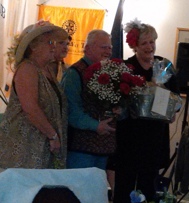 Rotary’s Debbie Graves, left, and Community Center Director Jane Good, second from right, assist Richard Plunkett with his grand prize. JANE CARPENTER/Boothbay Register