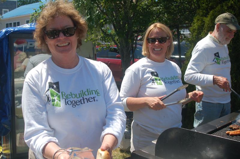Sarah Giles, Stephanie Hawke and John Bertolet serve hamburgers for Rebuilding Together. ART MAYERS/Boothbay Register