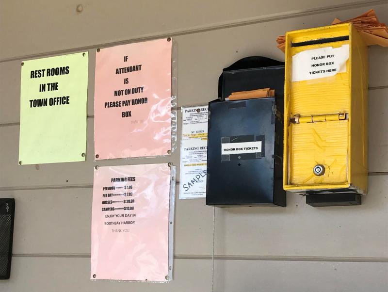 Signs and honor boxes in the building in the Howard Street lot. KELLIE BIGOS/Boothbay Register