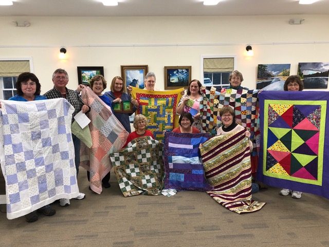 Quilters show their work. From left are, standing, Irene Fowle, Brian McGrath, Jean Huber, Karen Keyes, Colleen Gaffey, Cindy Goodwin, Rebecca Townsend, Debbie Lewis; front, Jackie Manton, Janet Clark and Marty Helman. Steve Demeranville photo