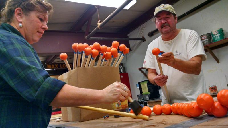 Becky Barter, left, and painting specialist John LaCharite add a shellac finish to the handles for the puffin toys. MARGARET HOFFMAN/Boothbay Register