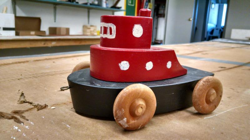 Hodgdon Yacht Services woodworkers Jim Jones and Dave Radtke used the 20-year-old tugboat sample to make new templates and patterns for this year's toy project. MARGARET HOFFMAN/Boothbay Register