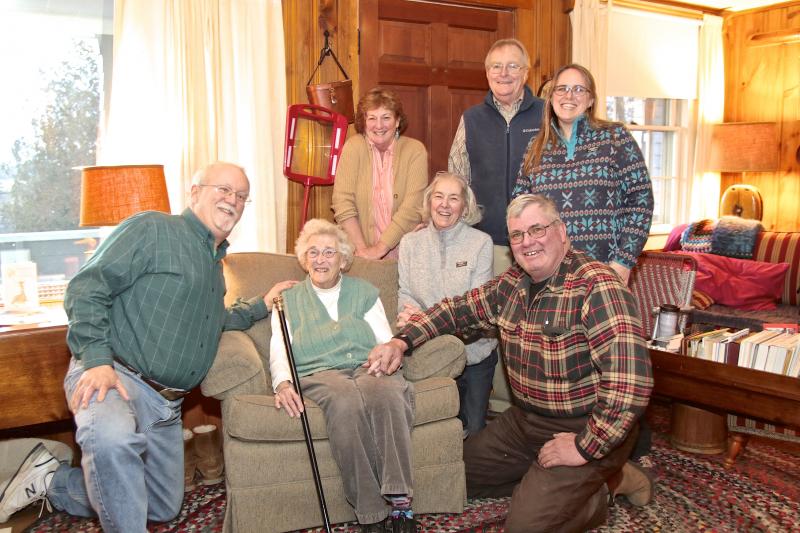 Jean Thompson holds Southport’s Boston Post Cane, presented to her by the town’s selectmen (all kneeling, from left), Smith Climo, Mary Lou Koskela (Jean’s daughter) and Gerry Gamage. Looking on are Jean’s other daughter, Anne Maher, son-in-law Phil Koskela and granddaughter, Carrie Koskela. Robert Mitchell photo