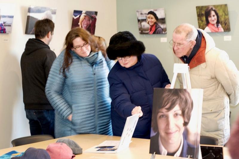Taking in the “Women of the Boothbay Region” portrait show and some Bob Crink extras on the table. LISA KRISTOFF/Boothbay Register
