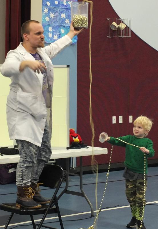 This Edgecomb Eddy student tries to catch a string of beads during “Catalyst Corey” of Mad Science of Maine’s demonstration Jan. 15 during a joint assembly of Southport and Edgecomb elementary school students. BILL PEARSON/Boothbay Register