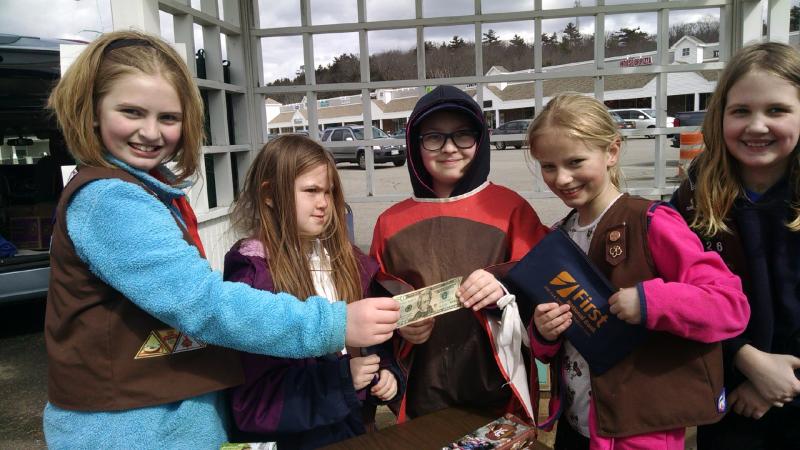 The girls proudly deposit a $20 bill from a big sale in the cash bag and record the buyer’s cookie choices on their sales sheet. MARGARET HOFFMAN/Boothbay Register