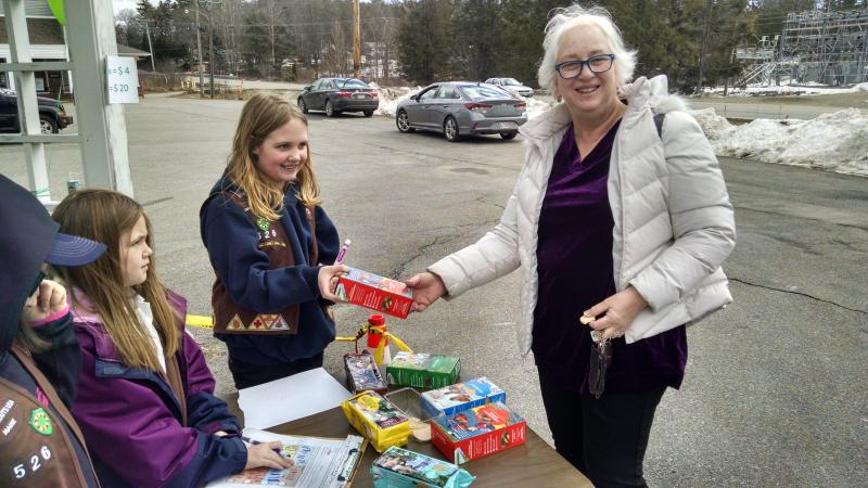 Carol Copan of Wiscasset was on a trip to source some craft supplies at the St. Andrews and Creature Comforts thrift stores in Boothbay Harbor when Girl Scout Troop 526 lured her over to its cookie sake booth at the Meadow Mall. MARGARET HOFFMAN/Boothbay Register