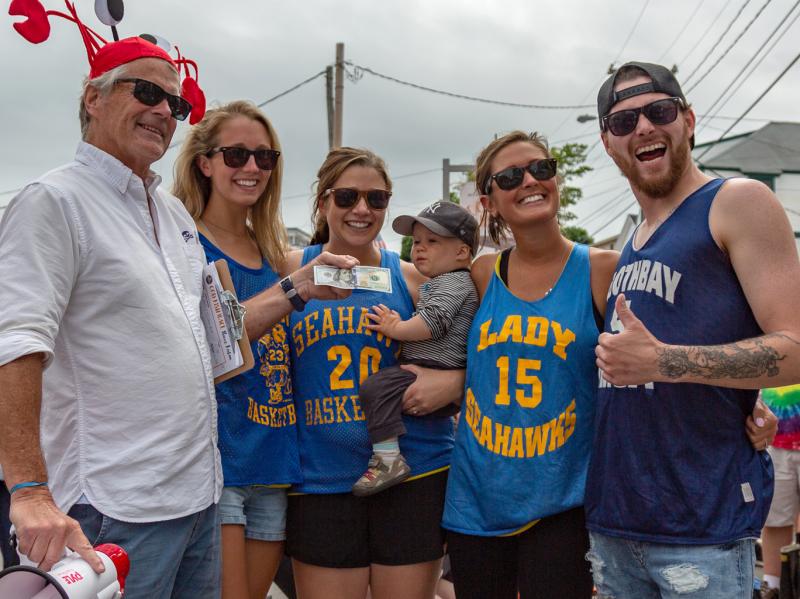 Jack Herger hands the winning prize to cod fish relay race winners, from left, Alexandra Andrews, Lauren Andrews, Kristin Sibley and Brad Bonny. Falene Petrik photo
