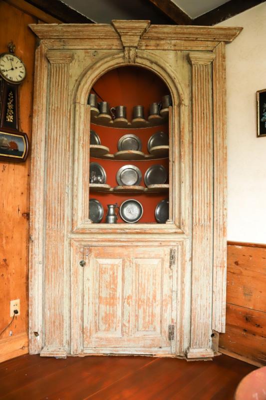 18th century architectural corner cupboard, free-standing with deep shaped shelves, fluted pilasters and paneled doors, 94” tall.