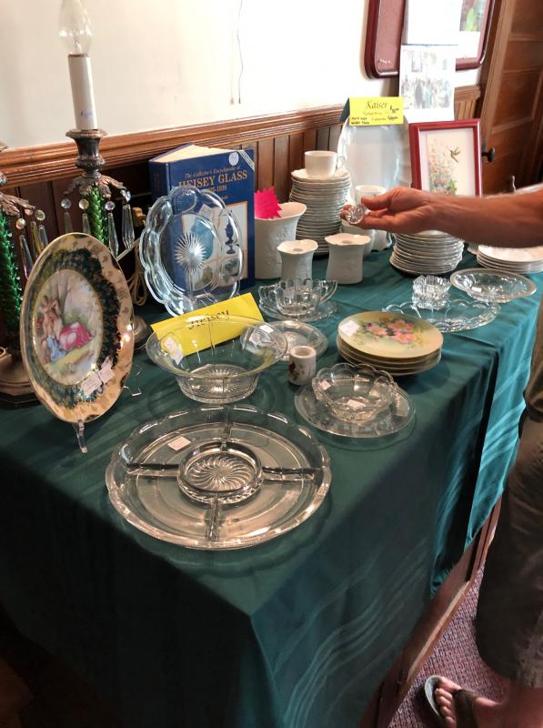 A fair attendee looks at antique dishware at Southport Country Fair. CRAIG LANCASTER/Boothbay Register Southport, Southport Country Fair, Southport Town Hall, Southport United Methodist Church