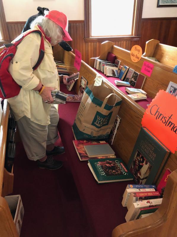 A prospective book buyer. CRAIG LANCASTER/Boothbay Register Southport, Southport Country Fair, Southport Town Hall, Southport United Methodist Church