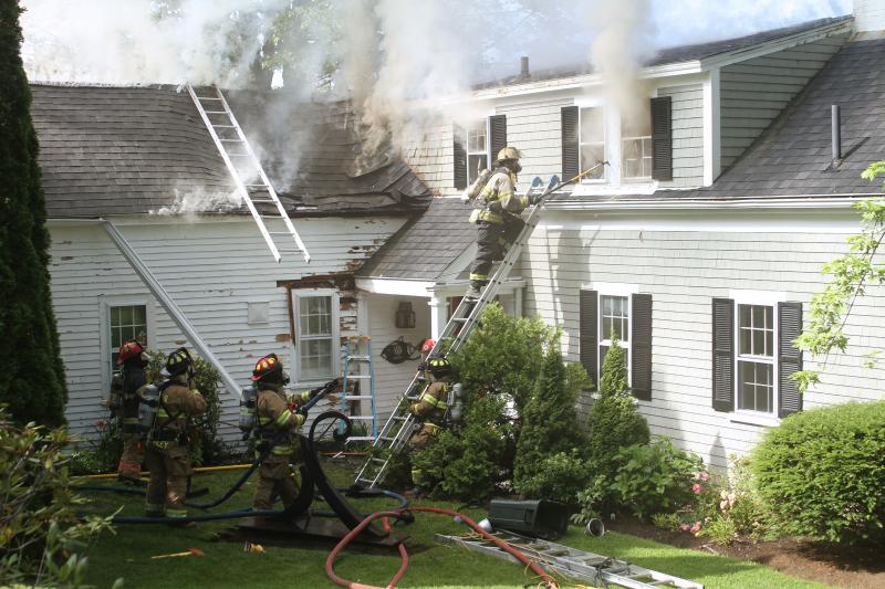Firefighters work to gain access to the second story of the house. STEVE EDWARDS/Boothbay Register