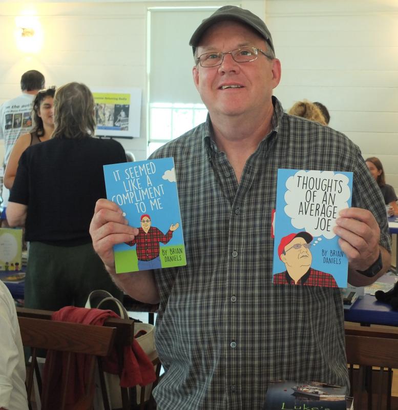 Maine humorist Brian Daniels displays two of his books during the July 27 Books in Boothbay event. BILL PEARSON/Boothbay Register