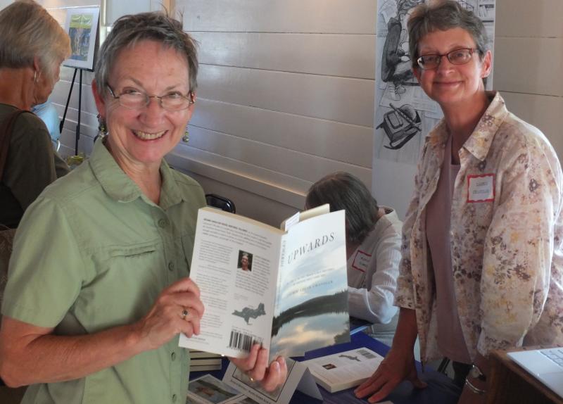 Boothbay resident Leanne Pander, left, peruses “Upwards,” a Laurie Chandler novel, July 27 during the Books in Boothbay event. BILL PEARSON/Boothbay Register