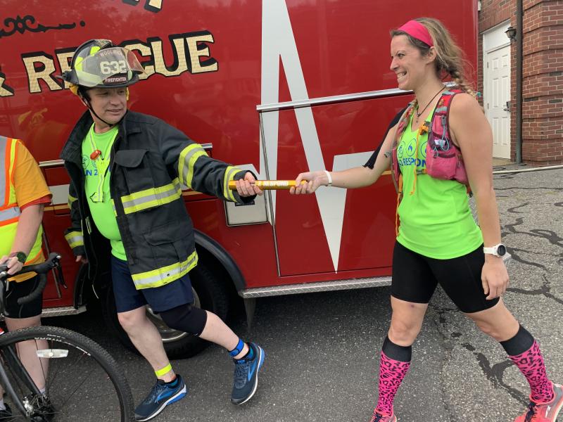 In Wiscasset Aug. 11, Woolwich’s Danny Evarts takes the Run 2 Respond baton from Portland’s Tanya Holbrook. SUSAN JOHNS/Wiscasset Newspaper