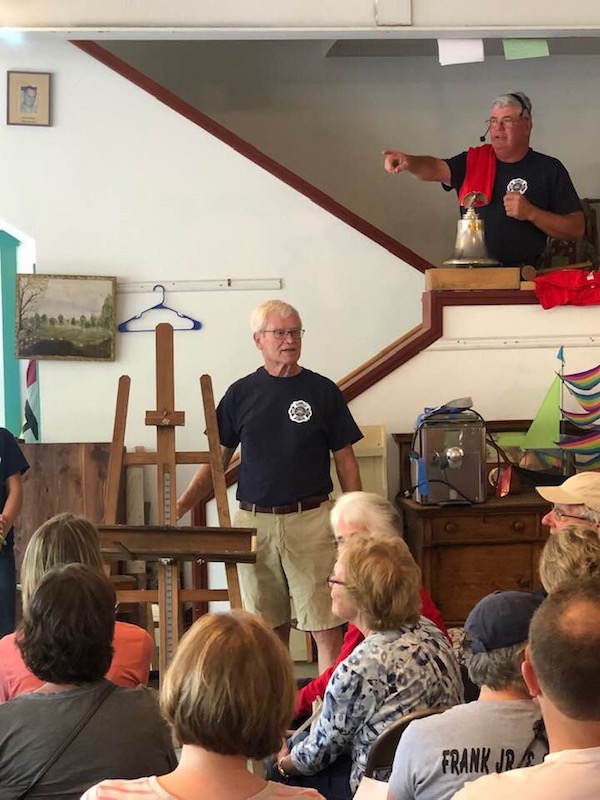 Peter Kidder displays a vintage art easel as Fire Chief Gerry Gamage keeps track of the bids. Courtesy of Amy Hilstrom