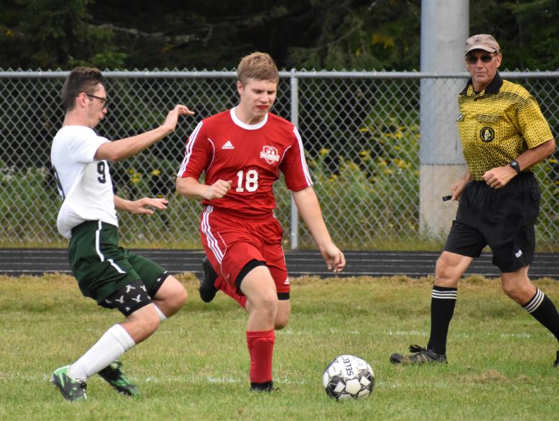 Wolverine Josh Jones and Carrabec’s Dimitri Turcotte pursue a loose ball. PHIL DI VECE/Wiscasset Newspaper