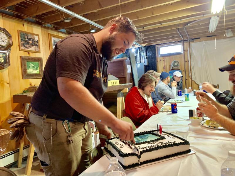 Saturday night at the Percival building named for museum founder Harry Percival, Dan Malkowski cuts his birthday cake to share with the roomful of fellow volunteers who sang him
“Happy Birthday.” SUSAN JOHNS/Wiscasset Newspaper