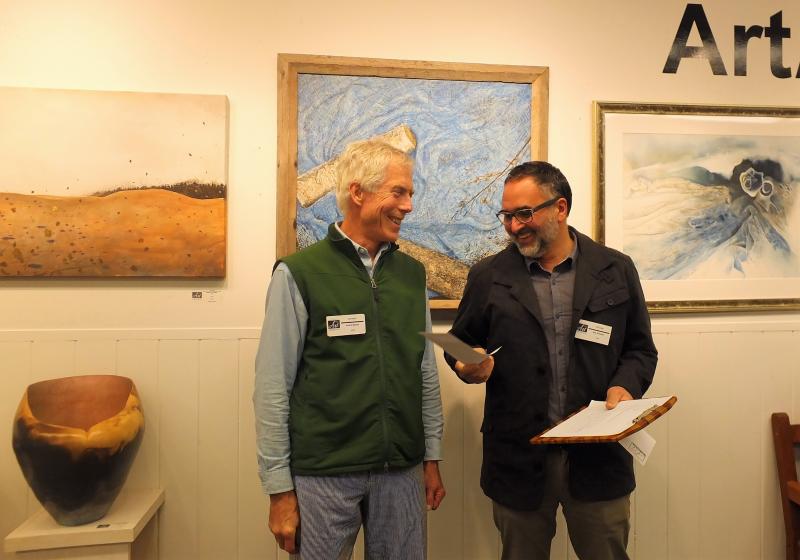 A surprised Andre Benoit accepts the Best In Show prize from juror Roy Germon. LISA KRISTOFF/Boothbay Register Andre Benoit and juror Roy Germon ARTinME 2019
