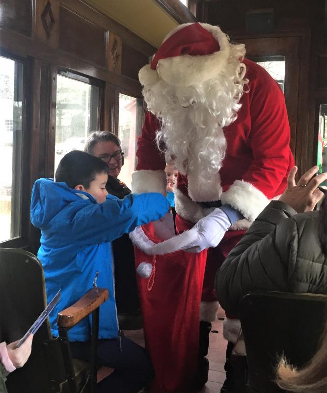 Santa Claus opens his bag of goodies on the train during the North Pole Express event at the Boothbay Railway Village. File photo