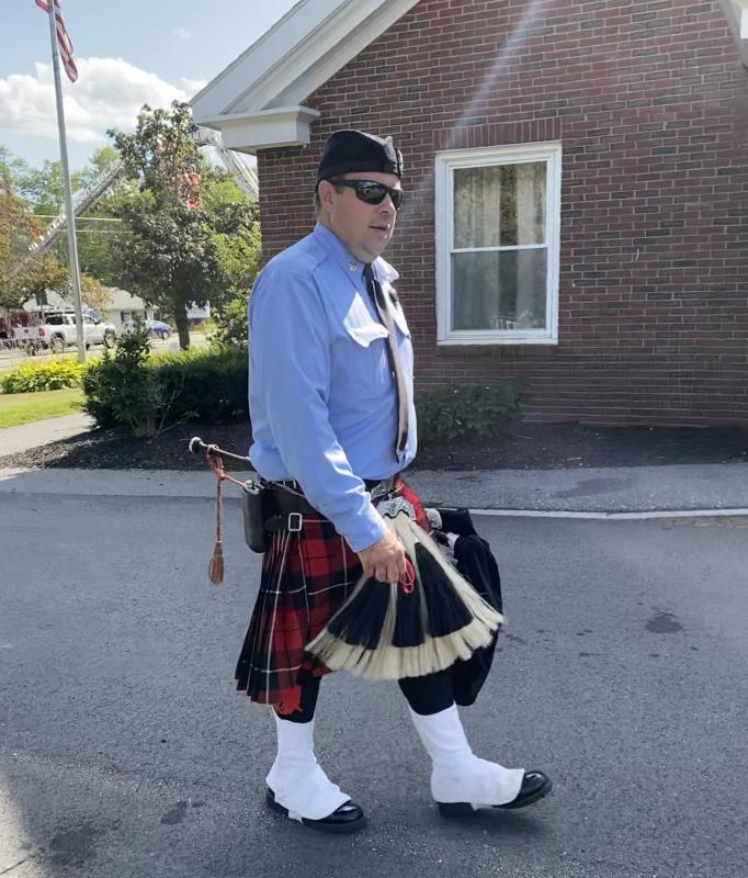 A member of a Bergen County, New Jersey firefighters pipe band passes the Wiscasset town office after the band took part in the service for Rich Kubler at First Congregational Church of Wiscasset Aug. 1. SUSAN JOHNS/Wiscasset Newspaper