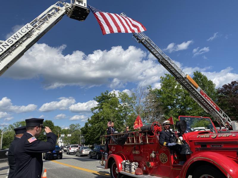 Hampden firefighter Oliver Bianchi salutes as the casket of Rich Kubler passes aboard a Bath fire truck on Route 1 after Saturday’s memorial service at First Congregational Church of Wiscasset. SUSAN JOHNS/Wiscasset Newspaper