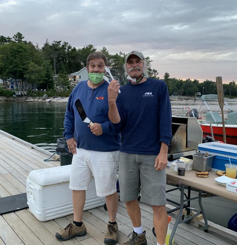 Linekin Bay Resort owners/grill masters Scott Larson, left, and Steve Malcom cooked up picnic fare for the outdoor film event. Erin Stodder photo