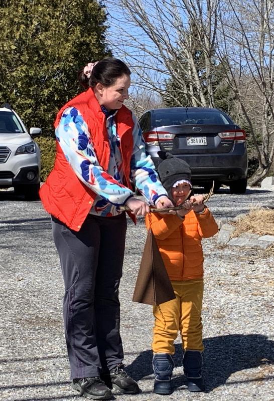 Helen Russell and son Ben, 4, ring a bell at noon March 22 as neighbors were also doing, in a Wiscasset observance residents kept up daily through the year. SUSAN JOHNS/Wiscasset Newspaper