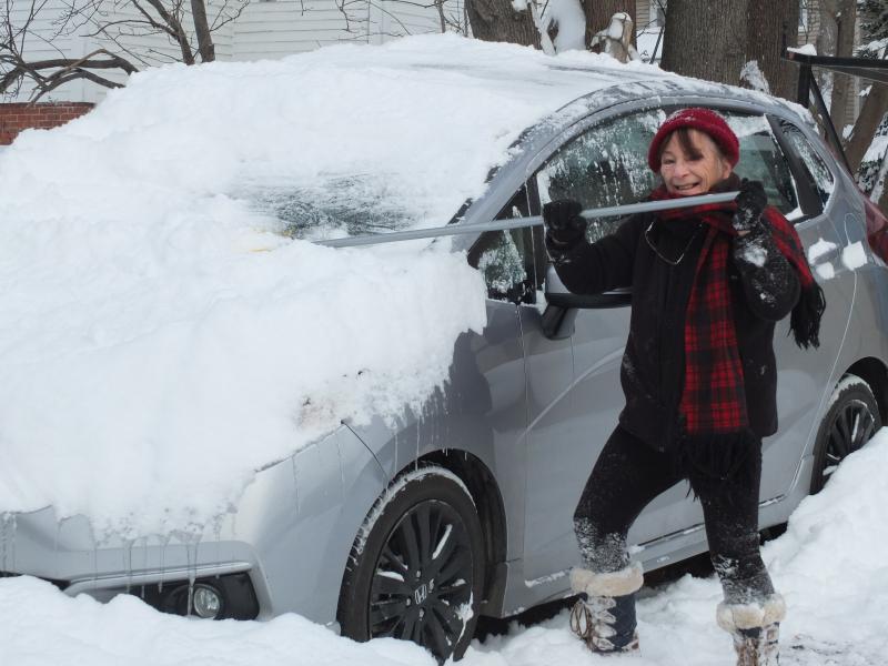 Boothbay Harbor resident Sue Decker brushes off her car Dec. 18 after a winter storm dropped seven inches of snow. BILL PEARSON/Boothbay Register