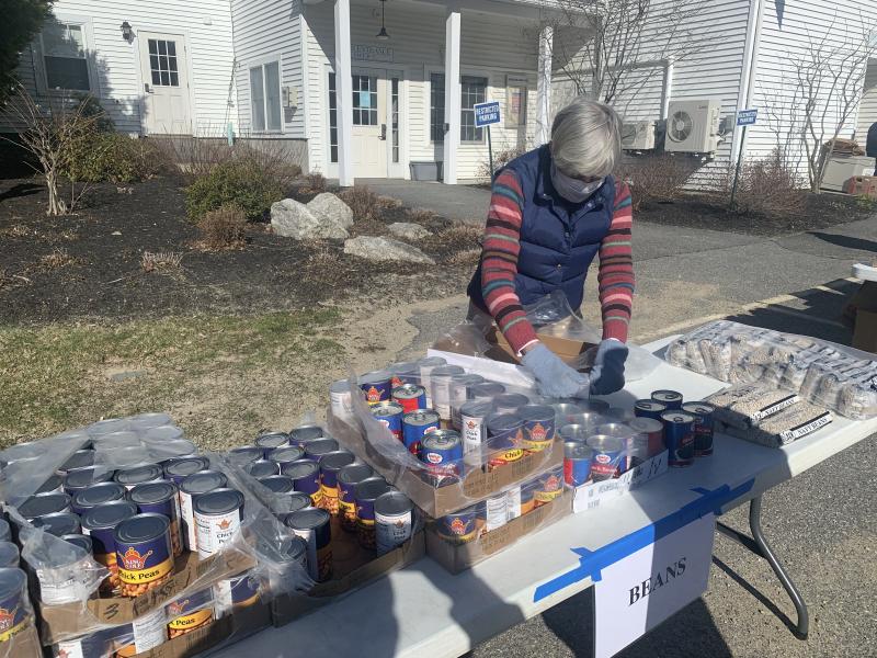 Food Pantry volunteer Jane Lunt stocks a table with canned beans. KEVIN BURNHAM/Boothbay Register