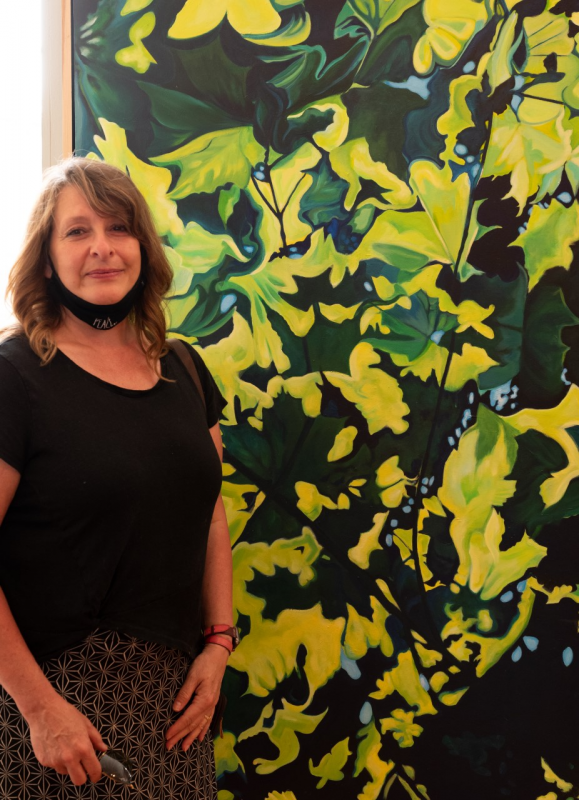 “What inspires artist Colleen Kearney-Graffam? The inter-connectedness of life systems with the natural and perceived mythical worlds. Here she is with her painting, “Look Up.” Photo by Bob Bond Colleen Kearney-Graffam