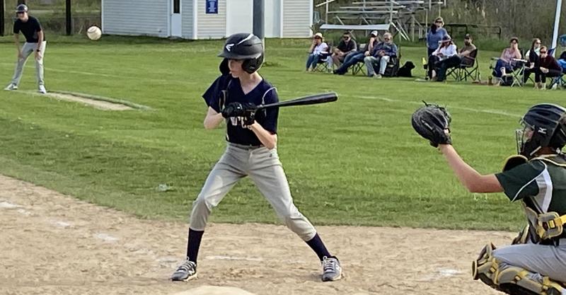 Sam Markowitz draws a ball against Nobleboro Central School while Coach Finn Harkins looks on from near first base. Courtesy of Shanon Cotta