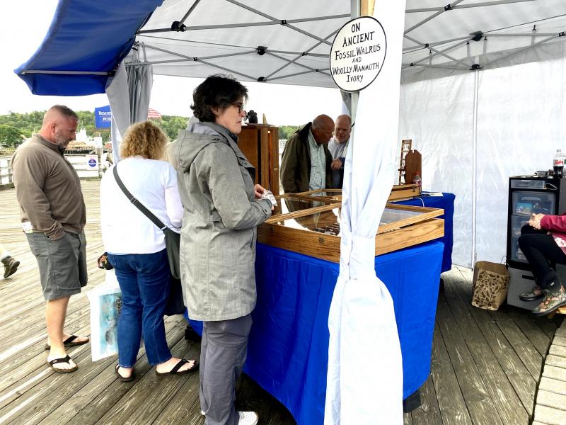 Shoppers peruse work at Chris Cambridge’s The Scrimshaw Workshop. ISABELLE CURTIS/Boothbay Register