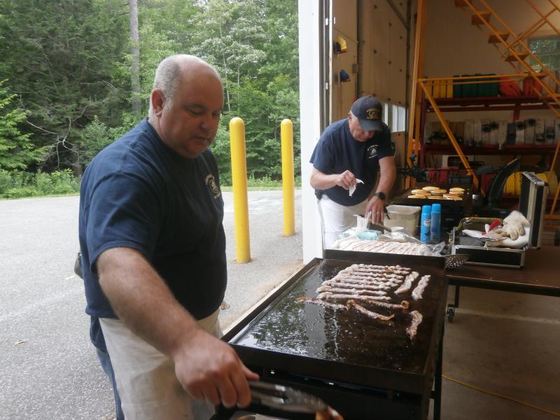 John Potter fries the bacon. ART MAYERS/Boothbay Register