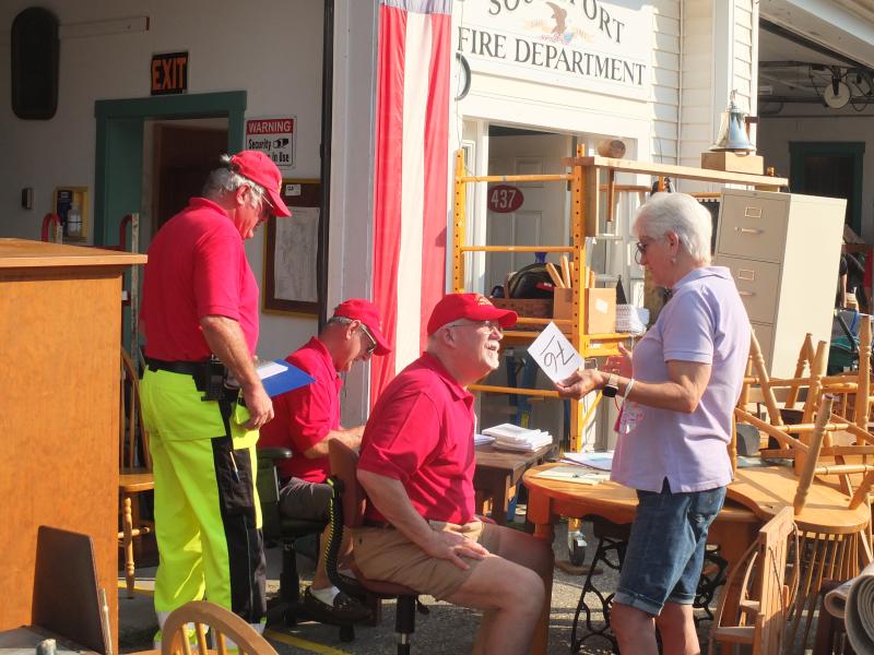 Southport fireman Smith Climo assists a customer at the annual fundraiser. BILL PEARSON/Boothbay Register
