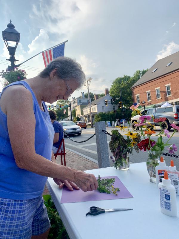 Nancy Roby creates a mandala with items from Jan Whitfield’s Wiscasset garden. Whitfield contributed zinnias, brown-eyed Susans and Russian sage to the activity. SUSAN JOHNS/Wiscasset Newspaper