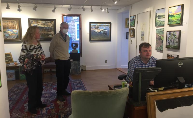 Andrew Gleason looks up information for a couple stopping by Gleason Fine Art. LISA KRISTOFF/Boothbay Register