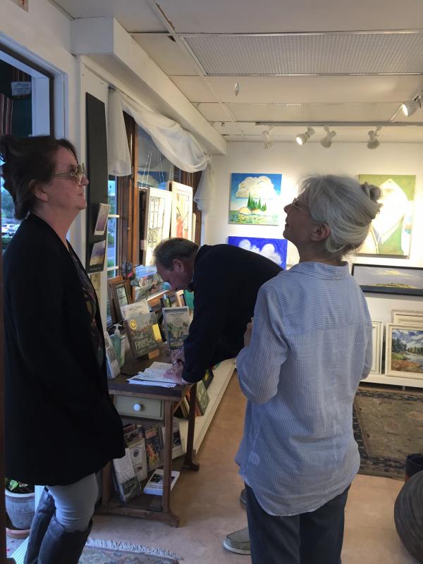 Signing the guest book and chatting with artist Lynne Seitzer at Joy to the Wind. LISA KRISTOFF/Boothbay Register