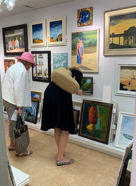 Art lovers peruse the paintings at Joy to the Wind. Courtesy of the gallery