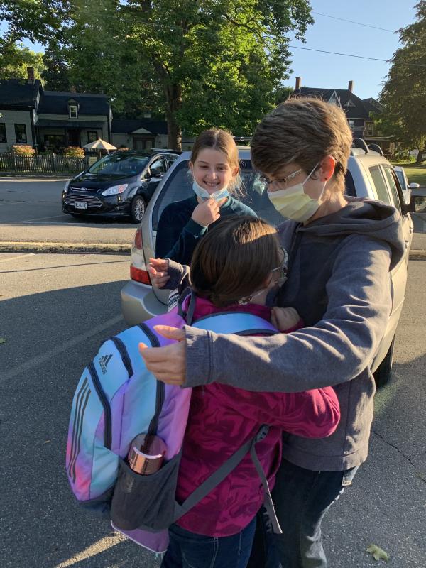 Elizabeth Freeman shares a first day back at school hug with daughters Haley Dumais, 10, foreground, and Lily Dumais, 12, in the Wiscasset Elementary School lot Sept. 7. SUSAN JOHNS/Wiscasset Newspaper