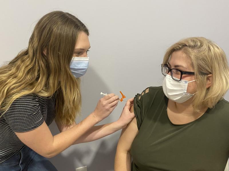 Hannah Morley, left, is on a college break from her rotation. She is working at Nathan’s Wellness Pharmacy and Apothecary in Boothbay Harbor giving co-owner Maria Jose Amor an inoculation. Courtesy photo