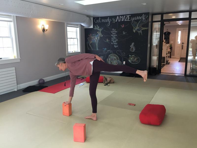 Wendy Johnson, teacher at Crow Point Yoga, prepares to move into Half Moon pose in front of the newly painted mural by Kathy Hartley and daughter Kelsey. LISA KRISTOFF/Boothbay Register