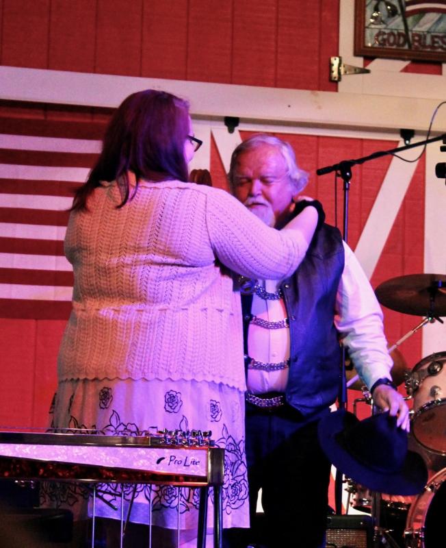 Brittany Reed places the Maine Country Music Hall of Fame medal on her father. Courtesy of Brittany Reed