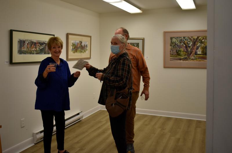 Jan van Hasselt, left, with some visitors from Pennsylvania talking about Tony’s art. LISA KRISTOFF/Boothbay Register