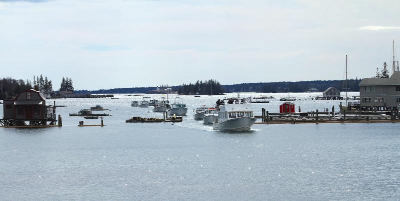 The parade of lobster boats comes through the Boothbay Harbor Footbridge for the very last time. (Photo by Steve Edwards)