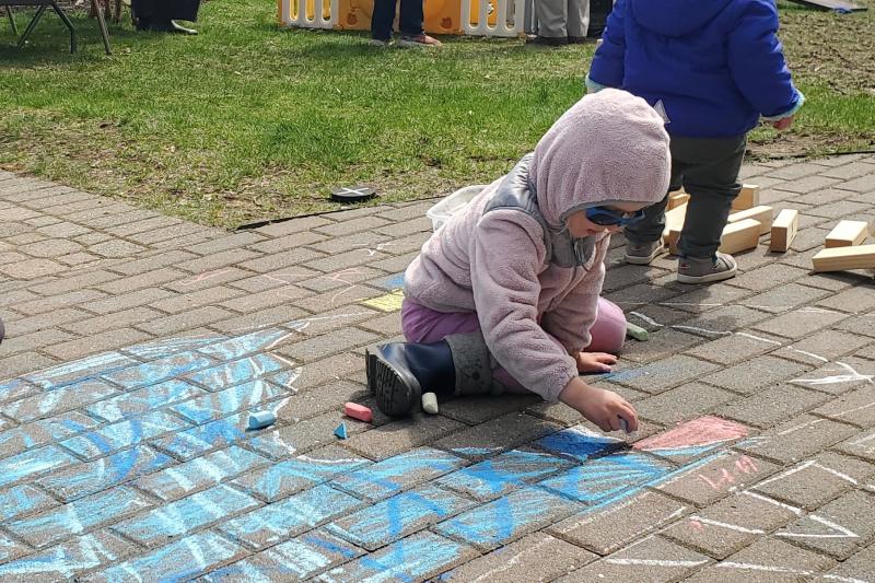 Luni Bauer, 4, makes chalk art to add to the mural near the library steps. FRITZ FREUDENBERGER/Boothbay Register