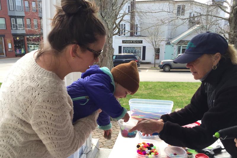 Pauline Dion, right, from Boothbay Sea and Science Center helps Taylor Spurgin and his mother, Heidi, make Earth Day themed-crafts. FRITZ FREUDENBERGER/Boothbay Register