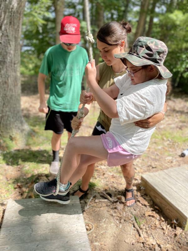 Matthias Fanslau helps Adventure Mentor Misha Barker support Harper Atwood on the low ropes course during Sunbeam Session. Courtesy of Hearty Roots