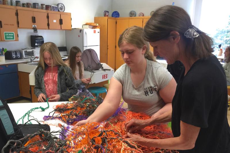 Pamela Moulton helps Addie Barter unravel reclaimed fishing rope for the BRES art project. In the background, from left, Brianna Campbell and Gabrielle Cassidy work on their own ropes. FRITZ FREUDENBERGER/Boothbay Register