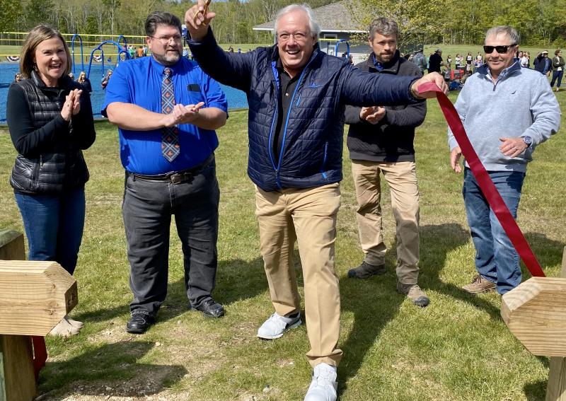 Local philanthropist Paul Coulombe cuts the ribbon May 26 during the ceremony for the new Little League baseball field’s opening. Michelle Amero photo